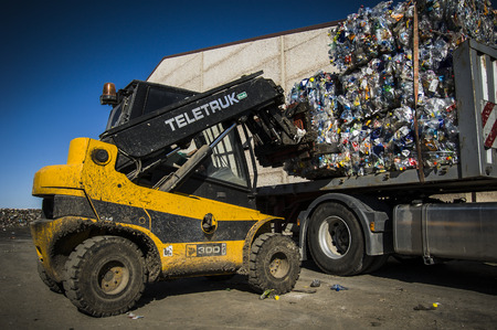 tractor loading piles of garbage in a truckのeditorial素材