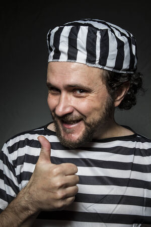 Imprisoned, Desperate, portrait of a man prisoner in prison garb, over white backgroundの写真素材