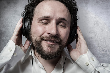listening and enjoying music with headphones, man in white shirt with funny expressions