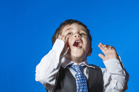 Leader, cute little boy portrait over blue chroma backgroundの写真素材