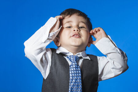 Leader, cute little boy portrait over blue chroma backgroundの写真素材
