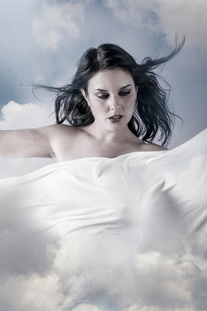 Environment, Beautiful woman in clouds, mithology concept. Brunette with long hair and white dress.の写真素材