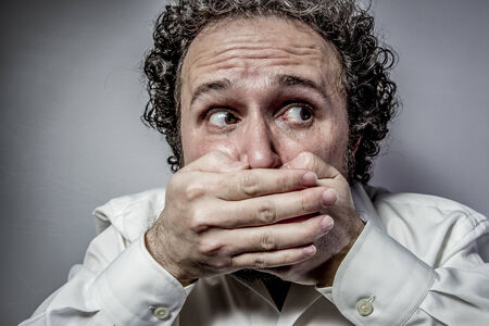 say nothing, silence, man with intense expression, white shirtの写真素材