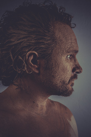 Face, athletic man with skin covered in mudの写真素材