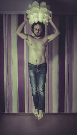 man floating in the air, grabbed the lampの写真素材