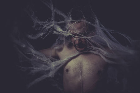 Dark Man trapped in a spider webの写真素材
