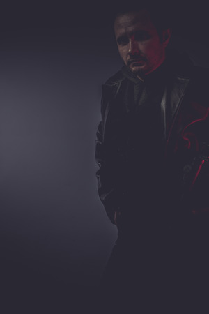 pistol portrait of stylish man with long leather jacket, gun armedの写真素材