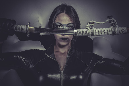 brunette girl dressed in black latex jumpsuitの写真素材