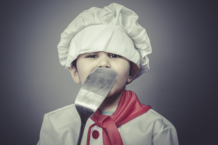 preparing food , child dress funny chef, cooking utensilsの写真素材