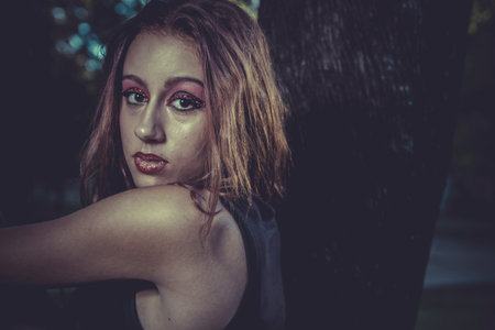 happy, redhead girl with black dress on a park