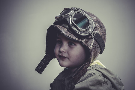 aviation, fun and funny child dressed in aviator hat and gogglesの写真素材