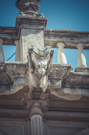 Scary, Stone gargoyle on the facade of the University of Alcala de Henares, Madrid Spainの写真素材