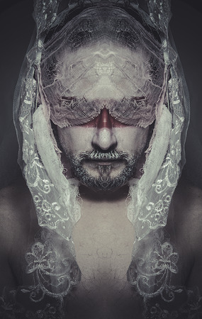 duality veiled mystery man in the face and red painted maskの写真素材