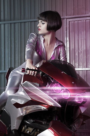Future, Beautiful brunette woman wearing latex mounted on a motorcycle with a modern designの写真素材