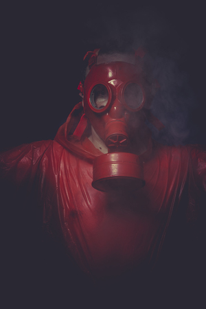 Problem, A man in a gas mask over  the smoke. black background and red colorsの写真素材