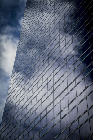 skyscraper with glass facade and clouds reflected in windowsのeditorial素材