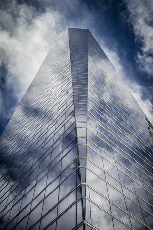 skyscraper with glass facade and clouds reflected in windowsのeditorial素材