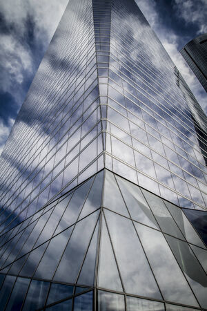center, skyscraper with glass facade and clouds reflected in windowsのeditorial素材