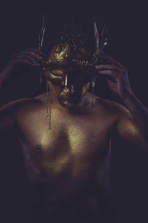 golden bodypaint, man with gold helmet, ancient warrior deity