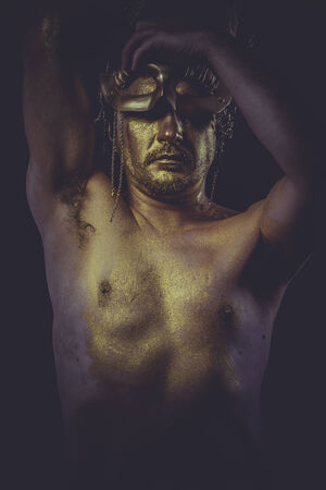 painted golden bodypaint, man with gold helmet, ancient warrior deityの写真素材