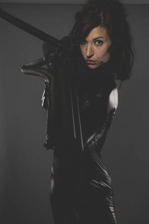 modern, sexy woman dressed in black latex, future concept and new technologiesの写真素材
