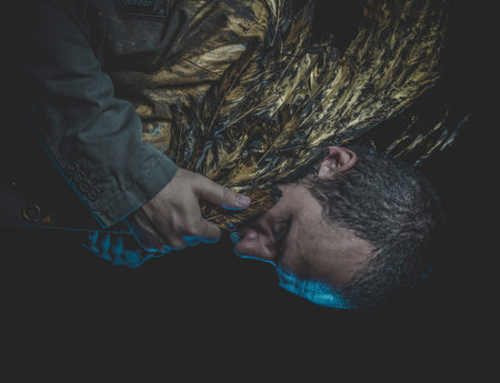 Fallen angel, man beard and suit made with golden wingsの写真素材