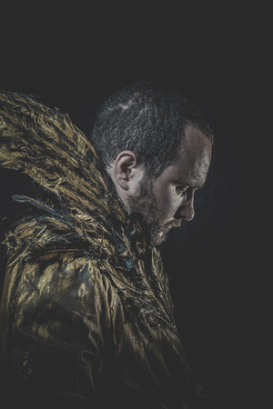 Halloween Fallen angel, man beard and suit made with golden wingsの写真素材