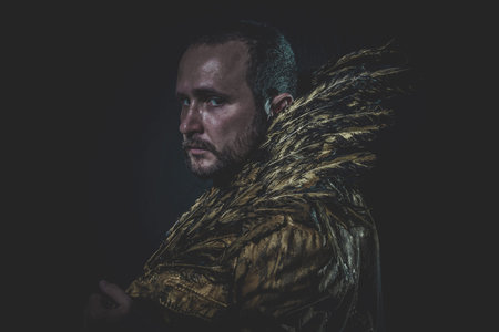 Fallen angel, man beard and suit made with golden wingsの写真素材