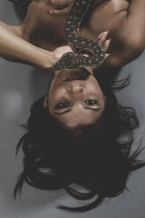 Sensual warrior tattooed woman with big snake and iron corsetの写真素材