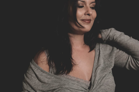 beautiful young brunette with sexy appearance, wearing a thin sweater grayの写真素材