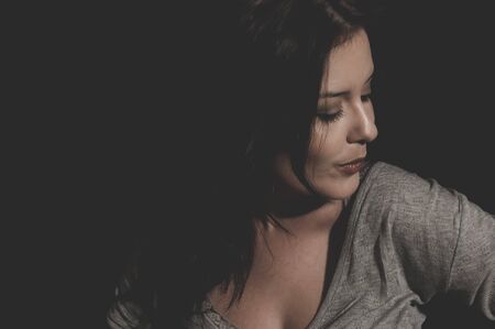 beautiful young brunette with sexy appearance, wearing a thin sweater grayの写真素材