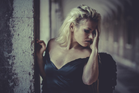 Romantic Blonde angel, young woman with black wings, autumn sceneの写真素材