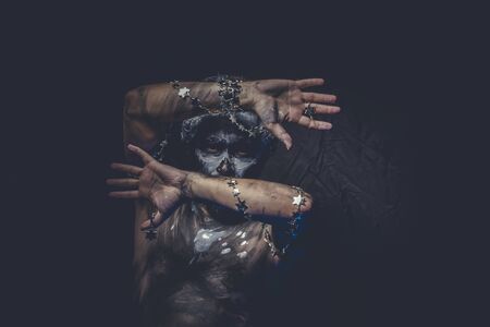 naked man covered with paint and mud skinの写真素材