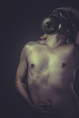 concept of risk of contamination, naked man with gas maskの写真素材