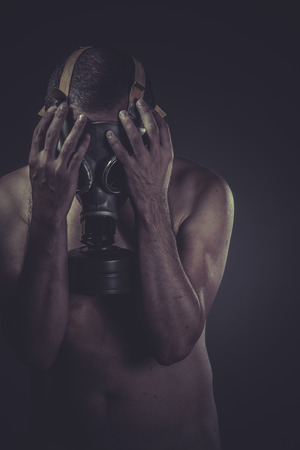 Waste, concept of risk of contamination, naked man with gas maskの写真素材