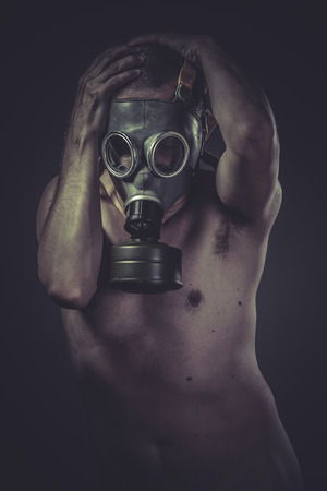 Waste, concept of risk of contamination, naked man with gas maskの写真素材