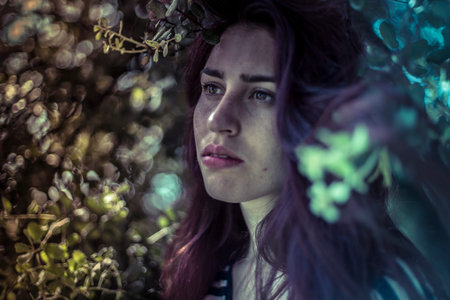 Feeling blue, melancholy young girl in a forest with sad gesture
