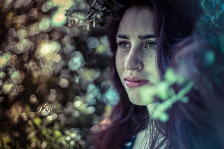 Feeling blue, melancholy young girl in a forest with sad gestureの写真素材