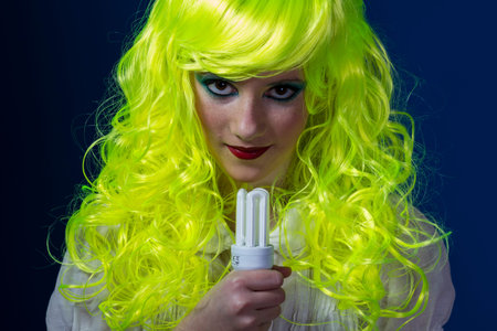 concept electricity, young girl with a light bulb in handの写真素材