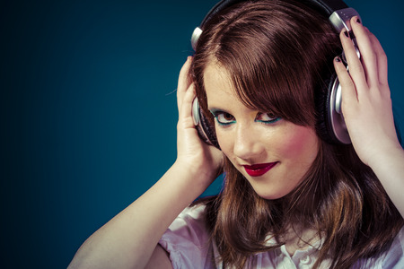 young girl listening music with huge headphonesの写真素材