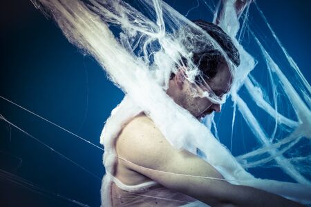 Net, naked man trapped in a huge spider webの写真素材
