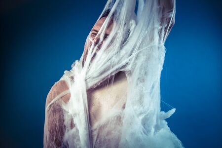 naked man trapped in a huge spider webの写真素材