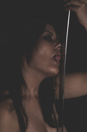 Sensual warrior wild woman with black hair and iron swordの写真素材