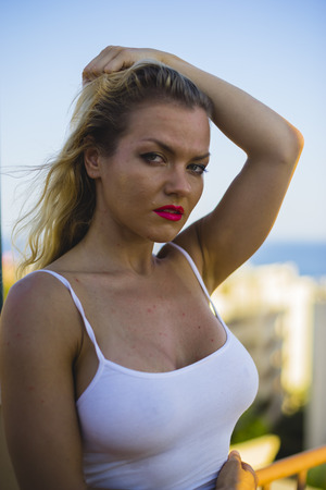 Relaxation, summer time, blonde with white shirt on a terrace in Spainの写真素材