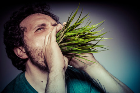 Rural, ecology concept, man with green grass in the mouth