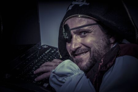 Thief, computer security, hacker pirate dress with hat and skullの写真素材