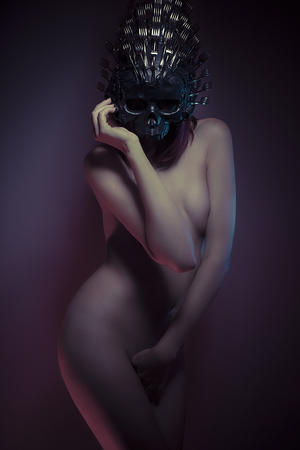 naked redhead girl with red corset and helmet skull with forksの写真素材