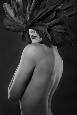 beautiful brunette woman with big black feathered maskの写真素材