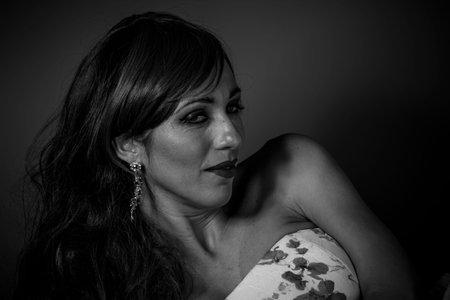 Beautiful red haired woman in white dress with flowers and sensual lookの写真素材