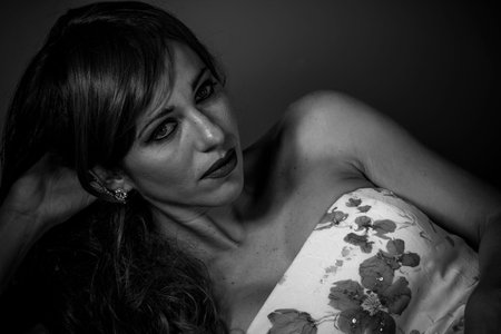 Beautiful red haired woman in white dress with flowers and sensual lookの写真素材